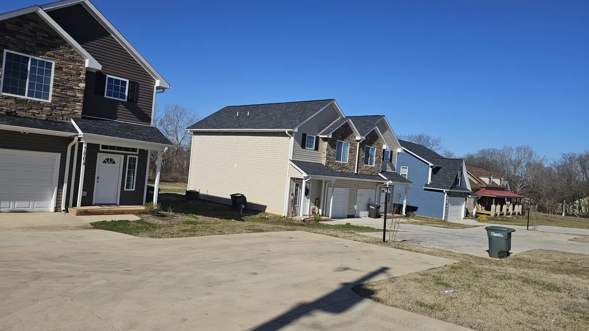 This exterior image showcases a row of houses with well-kept driveways and landscaped yards, suggesting a welcoming and family-friendly neighborhood environment. The scene hints at opportunities for neighborhood gatherings, outdoor play, and the kind of community connections that families value.