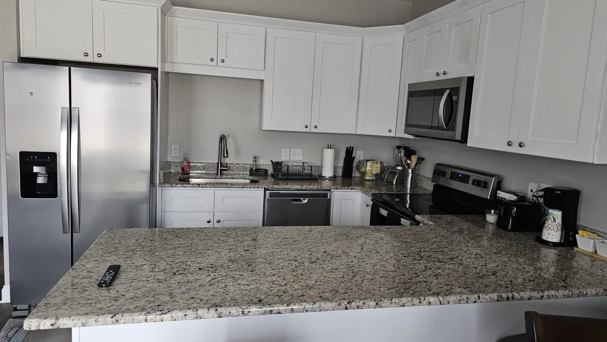 A welcoming kitchen scene featuring granite countertops, stainless steel appliances, and open cabinetry. The layout invites both cooking and entertaining, providing plenty of space for meal preparation and group activities.